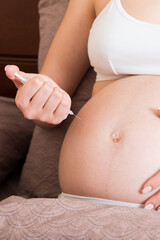 Pregnant woman with insulin syringe in home on bed. Pregnant diabetes concept