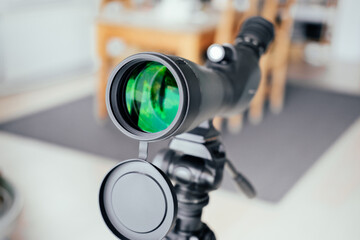 Modern telescope at home next to window