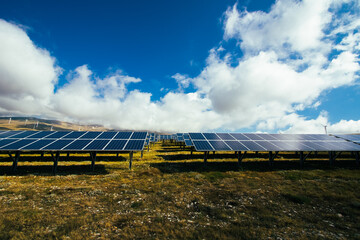 Fototapeta premium solar panel industry on the yellow and green mountain fields for environmentally sustainable green energy. The sun allows panels to take energy and create electricity for people in their homes.