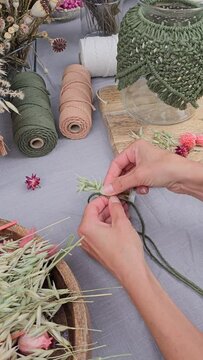 Frau bindet Trockenblumen zu einem Kranz, getrocknete Blumen, vertical Video
