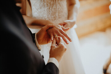Hochzeit - Brautpaar steckt sich Ring an 