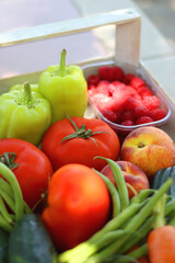 Wooden crate full of healthy seasonal fruit and vegetable, in the garden. Selective focus.
