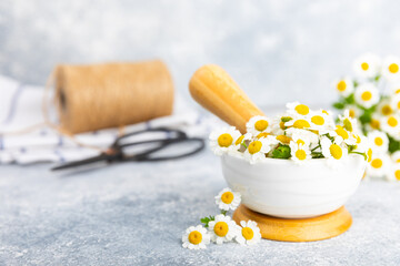 Chamomile flowers in mortar on a textured wooden table. Healing herbs. Alternative medicine. Healing. Homeopathy.Natural herbal organic cosmetics concept.Natural tea.Place for text. Copy space. 