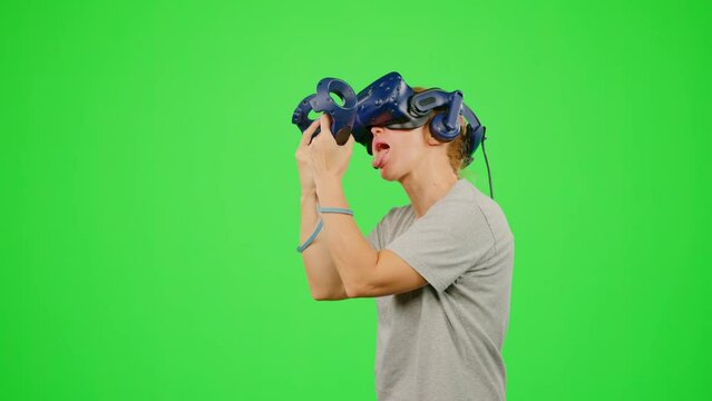 The girl in VR headset virtual reality gaming sex funny humor game.The woman is playing food game and lick mouth virtual banana.Chroma key green screen background.Concept silly comic crazy joke humor