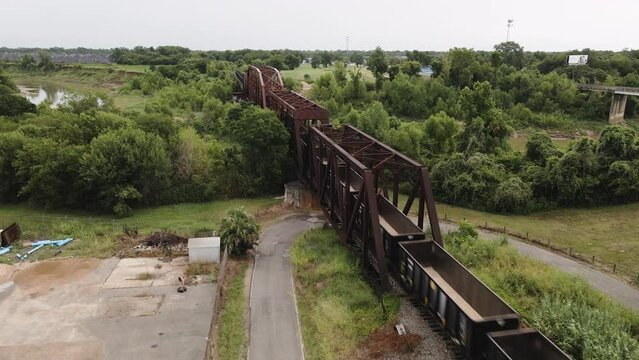Freight Train Crossing Iron Bridge Over Brazo River In Texas USA