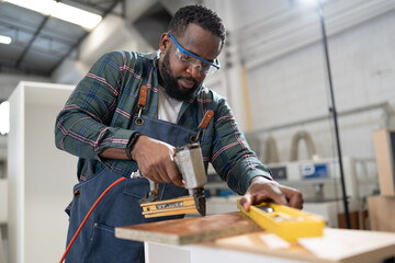 African American carpenter working at wood factory