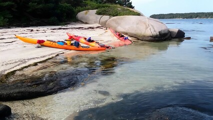 AI-generated illustration of colorful kayaks on the sandy shore with lush greenery and rocks.