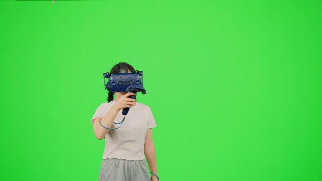 The little girl design artist VR headset drawing picture in virtual reality creativity game. Child in virtual reality paint imagination picture on chroma key green screen. Concept VR art design game