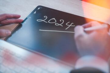 Concept for financial planning and reminder for 2024. man using digital tablet or smartphone...