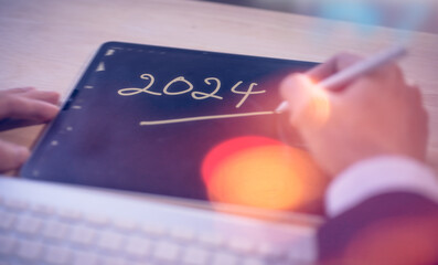 Concept for financial planning and reminder for 2024. man using digital tablet or smartphone...