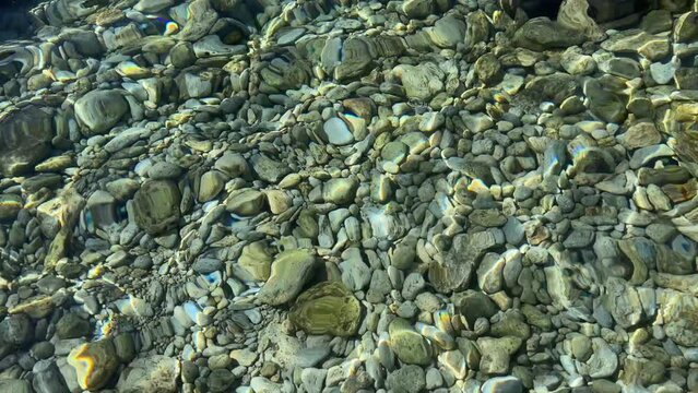 Clear sea water with stones and pebbles.