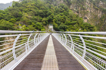 Fototapeta na wymiar Blow Bay Suspension Bridge or Mountain Moon bridge. A impressive breathtaking suspension bridge in the Taroko National park. View from the Buluowan Terrace Observation Deck. Taiwan landscape Nature