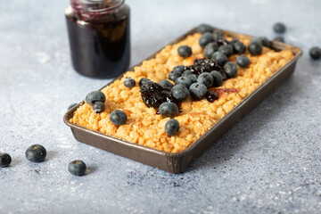 rustic grated cheese cake with berries , with blueberries and milk on a wooden background