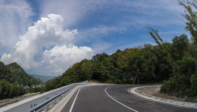 A new paved road in a picturesque mountainous area. Retaining wall and other elements of road construction. Russia, Sochi.