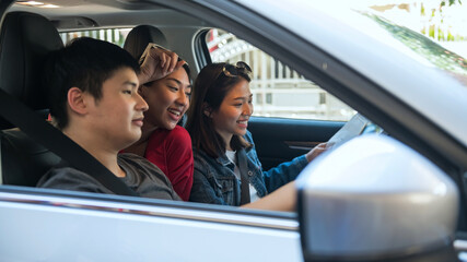 Asian friends check map to find location before driving suv car