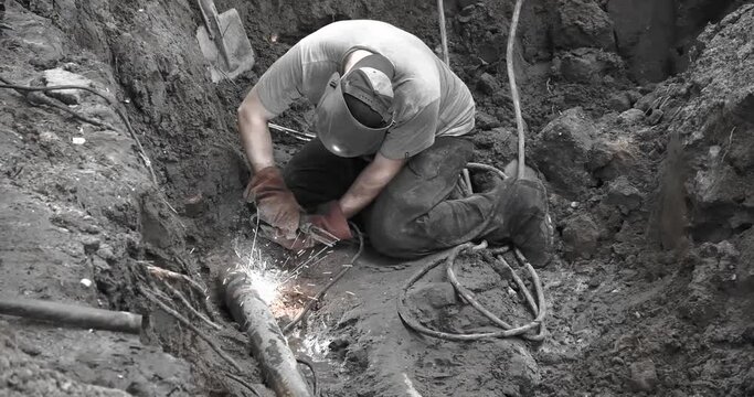 A utility worker eliminates an accident on a pipeline by electric welding
