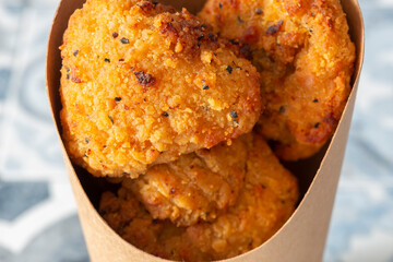 Southern fried chicken bites takeaway in a cardboard carton with a wooden fork. Biodegradable plastic free eco friendly takeaway container