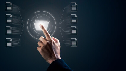 Businessman is pointing a finger against dark background.