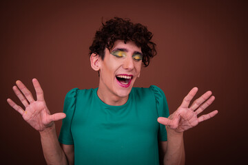 Funny drag queen posing in the studio on a brown background.