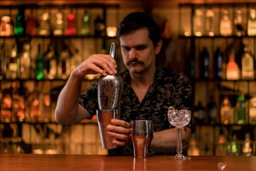 The process of making a cocktail by a bartender at the bar in a club bar the concept of love for...