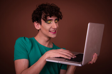 Funny Drag Queen poses in the studio on a brown background and communicates on the Internet.