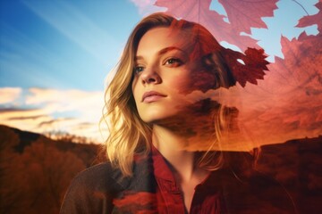a woman is looking up in the air with autumn leaves in the background