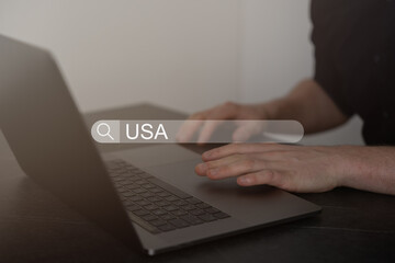 A businessman searches for the word USA in a search bar. Touch screen and a laptop.