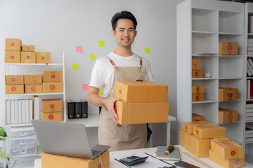 Start SME, small business entrepreneurs, SMEs of freelancers. Close-up shots of Asian women using smart phones and laptops with boxes. Online Marketing and SME Delivery Ideas.