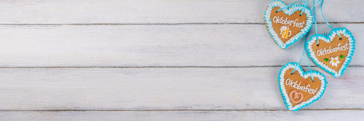 Background for Oktoberfest invitation, menu, greeting card, White wooden table or wall empty surface with checkered ribbon and heart cookies with Oktoberfest symbols - flower, beer, pretzel top view