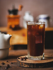 Cold Brew Iced Coffee americano in A Clear high glass on a table with blurry background