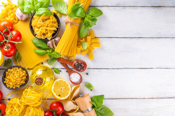 Various pasta with spices and ingredients for cooking. Preparation dinner, lunch background with fresh basil, tomatoes, spices, garlic and different sort and types of italian Mediterranean pasta