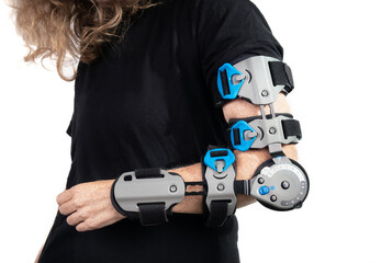 Woman with elbow brace or postoperative ROM brace. Medical device used to stabilize elbow after post-op surgery or dislocation and adjusting range of motion gradually. Selective focus.