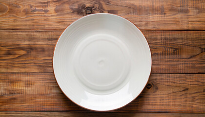 Empty plate on a wooden background. top view. Copyspace.