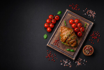 Delicious crispy croissant with salmon, lettuce, cheese and tomatoes