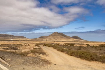 Papier Peint photo les îles Canaries View of the strange, unfriendly but fascinating deserted landscape of the island volcanoes of the center of Fuerteventura. North part of the island.