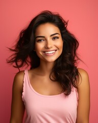 Fototapeta premium portrait of a beautiful young woman smiling on pink background stock photo