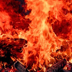 Big red and orange flames raging fire, wood and embers in the fire on a background of flames