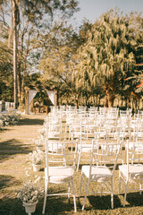 Wedding ceremony with pergola and white chairs in an open place in the middle of nature.