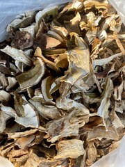 Background of dried edible mushrooms on the market closed up top view. White mushrooms dried for a sale.
