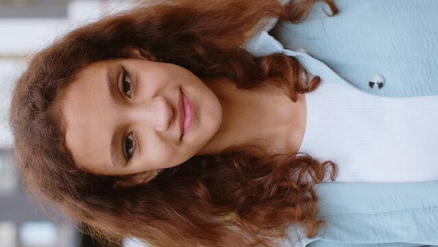 Close-up portrait of happy preteen child kid face smiling friendly open eyes glad expression looking at camera dreaming resting relaxation feel satisfied good news. Pretty girl in city street vertical