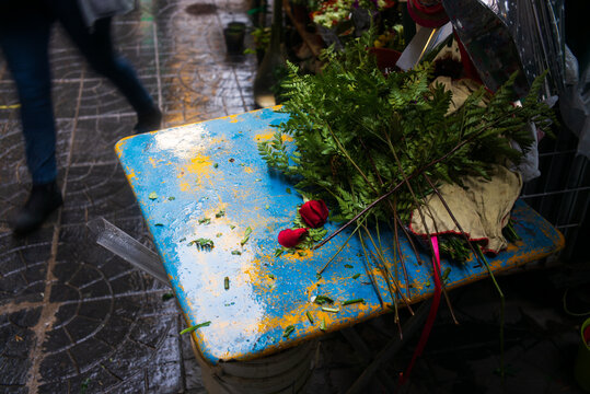 Cut roses on a worn blue and yellow table on the street in Buenos Aires, Argentina