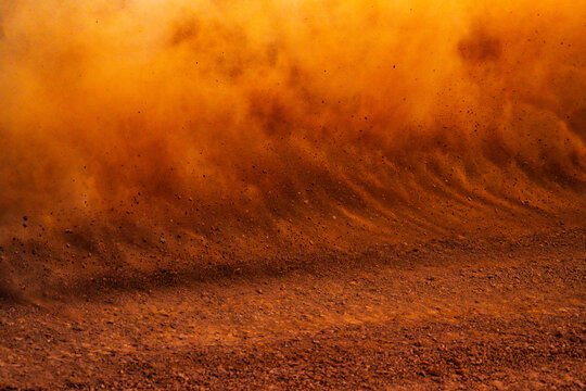 Dust kicked up by a race car on a dirt track 