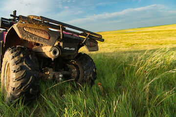 A four wheeler sits in tall grass in a South Dakota prairie at sunset