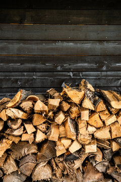 Cords of wood stacked against a wooden wall