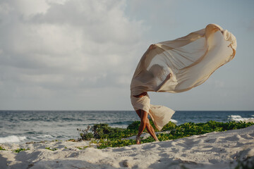 bailarin danzando con tela voladora en la playa