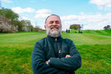 Happy retired man resting at public park in England
