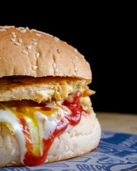 simple chicken burger with many sauces on black background