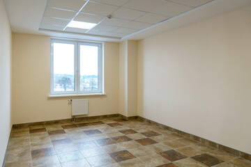 A bright empty space. An empty spacious office hall, clean white walls and bright lights. Window and door in the center of the room.