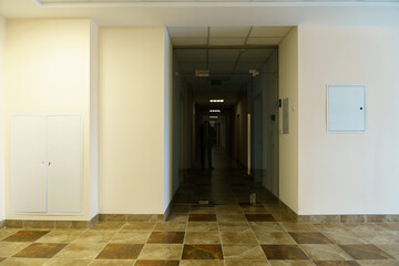 A bright empty space. An empty spacious office hall, clean white walls and bright lights. Window and door in the center of the room.