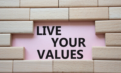 Live your values symbol. Concept words Live your values on wooden blocks. Beautiful pink background. Business and Live your values concept. Copy space.